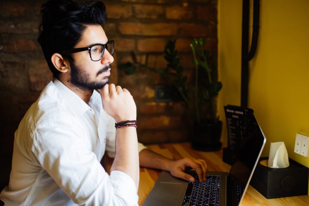 Pensive young engineer working on a laptop